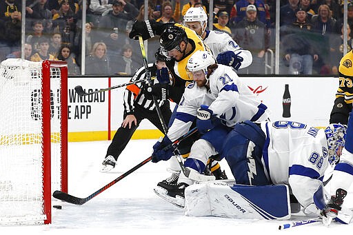 Tampa Bay Lightning's Brayden Point (21) reaches but cannot keep the puck from crossing the line for a goal by Boston Bruins' Sean Kuraly (52) during the second period of an NHL hockey game Saturday, March 7, 2020, in Boston. (AP Photo/Winslow Townson)