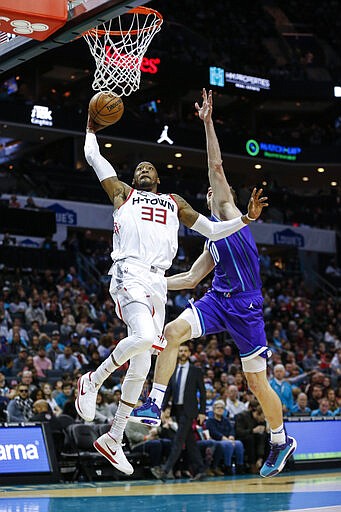 Houston Rockets forward Robert Covington, left, drives for a dunk against Charlotte Hornets center Cody Zeller during the second half of an NBA basketball game in Charlotte, N.C., Saturday, March 7, 2020. (AP Photo/Nell Redmond)