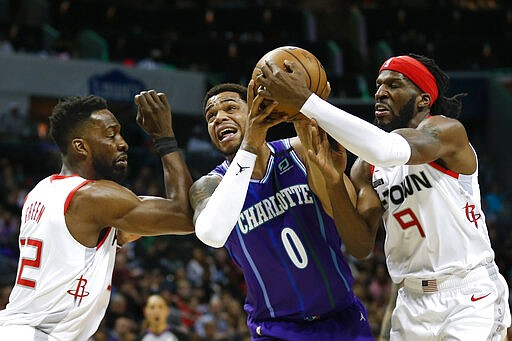 Charlotte Hornets forward Miles Bridges, center, loses control of the basketball as he drives between Houston Rockets forwards Jeff Green, left, and DeMarre Carroll during the first half of an NBA basketball game in Charlotte, N.C., Saturday, March 7, 2020. (AP Photo/Nell Redmond)