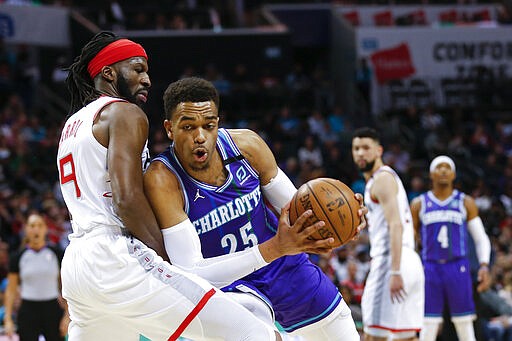 Charlotte Hornets forward P.J. Washington, right, drives into Houston Rockets forward DeMarre Carroll during the first half of an NBA basketball game in Charlotte, N.C., Saturday, March 7, 2020. (AP Photo/Nell Redmond)