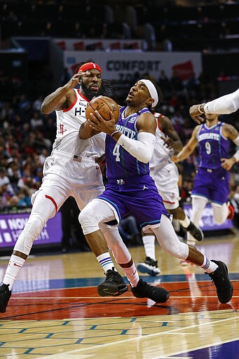 Charlotte Hornets guard Devonte' Graham, right, drives into Houston Rockets forward DeMarre Carroll during the first half of an NBA basketball game in Charlotte, N.C., Saturday, March 7, 2020. (AP Photo/Nell Redmond)