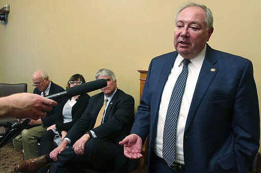 In this photo from Tuesday, Feb. 4, 2020, Kansas Senate Majority Leader Jim Denning, R-Overland Park, answers questions from reporters about Medicaid expansion following a news conference with other backers of a bipartisan plan at the Statehouse in Topeka, Kan. Denning is urging lawmakers not to add a work requirement to the expansion legislation. (AP Photo/John Hanna)