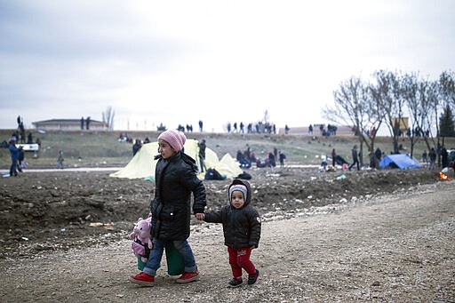 Migrant children walk in Edirne near the Turkish-Greek border on Thursday, March 5, 2020. Turkey said Thursday it would deploy special forces along its land border with Greece to prevent Greek authorities from pushing back migrants trying to cross into Europe, after Turkey declared its previously guarded gateways to Europe open. (AP Photo/Emrah Gurel)