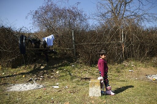 A girl holds a doll as migrants gather in Edirne, near the Turkish-Greek border on Friday, March 6, 2020. Clashes erupted anew on the Greek-Turkish border Friday as migrants attempted to push through into Greece, while the European Union's foreign ministers held an emergency meeting to discuss the situation on the border and in Syria, where Turkish troops are fighting. (AP Photo/Emrah Gurel)