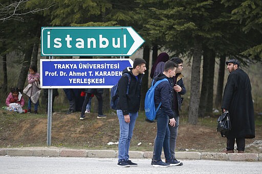 Migrants stand on the road in Edirne near the Turkish-Greek border on Thursday, March 5, 2020. Turkey has vowed to seek justice for a migrant it says was killed on the border with Greece after Greek authorities fired tear gas and stun grenades to push back dozens of people attempting to cross over. Greece had denied that anyone was killed in the clashes. (AP Photo/Emrah Gurel)