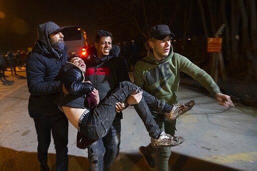 Migrants carry an injured man during clashes at the Pazarkule border gate, Turkey, at the Turkish-Greek border on Friday, March 6, 2020. Clashes erupted anew on the Greek-Turkish border Friday as migrants attempted to push through into Greece, while the European Union's foreign ministers held an emergency meeting to discuss the situation on the border and in Syria, where Turkish troops are fighting. (AP Photo)