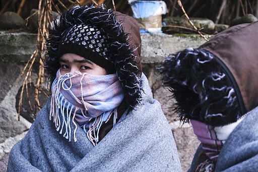 Migrants are wrapped in blankets in the village of Skala Sikaminias, on the Greek island of Lesbos, after crossing on a dinghy the Aegean sea from Turkey on Thursday, March 5, 2020. Turkey said Thursday it would deploy special forces along its land border with Greece to prevent Greek authorities from pushing back migrants trying to cross into Europe, after Turkey declared its previously guarded gateways to Europe open. (AP Photo/Alexandros Michailidis)