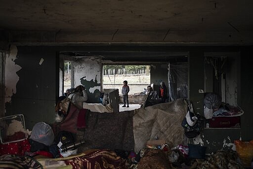 Migrants gather at an abandoned building in Edirne, near the Turkish-Greek border on Friday, March 6, 2020. Thousands of refugees and other asylum-seekers have tried to enter Greece from the land and sea in the week since Turkey declared its previously guarded gateways to Europe open. (AP Photo/Felipe Dana)