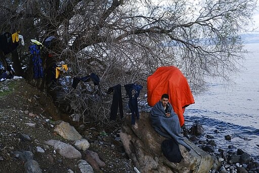 A migrant who arrived yesterday to Greece from Turkey tries to warm himself at the village of Skala Sikaminias, on the Greek island of Lesbos on Friday, March 6, 2020. Thousands of refugees and other asylum-seekers have tried to enter Greece from the land and sea in the week since Turkey declared its previously guarded gateways to Europe open. (AP Photo/Alexandros Michailidis)