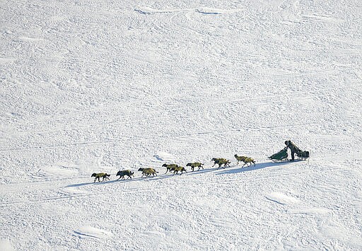 FILE - In this March 10, 2007 file photo Iditarod Trail Sled Dog Race front runner, four-time Iditarod champion Jeff King of Denali Park, Alaska, drives his dog team through the wind on the Yukon River near the Eagle Island, Alaska. When 57 mushers line up Sunday, March 8, 2020 for the official start of the Iditarod Trail Sled Dog Race, it will be the second-smallest field in the past two decades.  (AP Photo/Al Grillo,File)