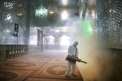 FILE - In this March, 6, 2020, file photo, a firefighter disinfects the shrine of Saint Saleh to help prevent the spread of the new coronavirus in northern Tehran, Iran. As cases of the coronavirus surge in Italy, Iran, South Korea, the U.S. and elsewhere, many scientists say it's plain that the world is in the grips of a pandemic &#151; a serious global outbreak. (AP Photo/Ebrahim Noroozi, File)