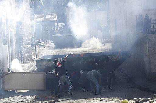 FILE - In this June 28, 2019 file photo, Palestinians clash with Israeli police in the Palestinian neighborhood of Issawiya in East Jerusalem, a day after a Palestinian was shot and killed by police during a protest in the same neighborhood. Nearly every day for the last nine months Israeli police have stormed into Palestinian neighborhood of Issawiya in east Jerusalem in a campaign they say is needed to maintain law and order. Rights groups say that in addition to searching houses and issuing fines, they have detained hundreds of people &#151; some as young as 10, on suspicion of stone-throwing. (AP Photo/Mahmoud Illean, File)