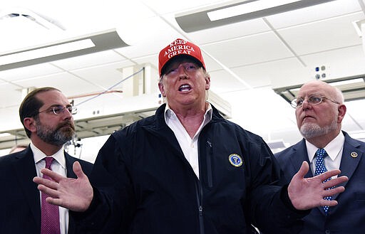 President Donald Trump speaks to members of the press as Health and Human Services Secretary Alex Azar, left, and CDC Director Robert Redfield, right, at the headquarters of the Centers for Disease Control and Prevention in Atlanta on Friday, March 6, 2020. (Hyosub Shin/Atlanta Journal-Constitution via AP)