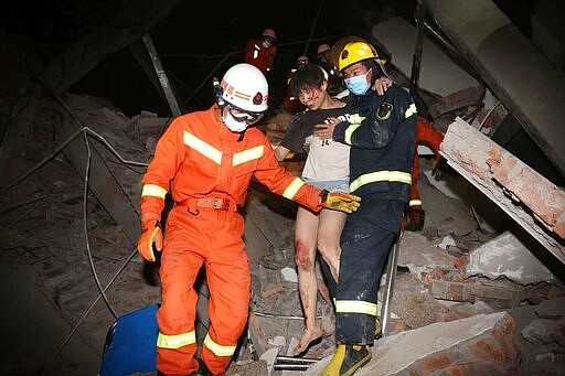 Rescuers help a woman from the rubble of a collapsed hotel building in Quanzhou city in southeast China's Fujian province Saturday, March 07, 2020. The hotel used for medical observation of people who had contact with coronavirus patients collapsed in southeastern China on Saturday, trapping dozens, state media reported. (Chinatopix via AP)