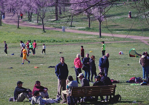 People enjoy the good weather in a park in downtown Rome, Saturday, Mar. 7, 2020. Following the coronavirus outbreak Italy has asked people to maintain a one-meter (three-foot) distance from strangers in public, to refrain from unnecessary travel and to avoid gatherings. Schools are shut down through March 15 nationwide and remote working has been advocated. While museums, which had been closed in the north, reopened with the one-meter rule being enforced, cinemas and theaters remain closed in northern Italy. (AP Photo/Domenico Stinellis)