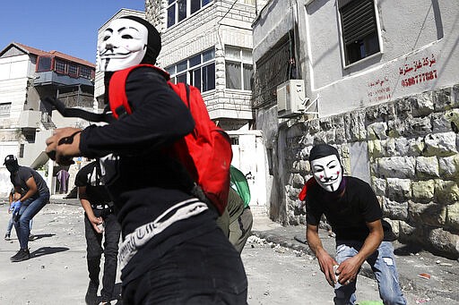 FILE - In this June 28, 2019 file photo, Palestinians clash with Israeli police in Jerusalem's Palestinian neighborhood of Issawiya, a day after a Palestinian was shot and killed by police during a protest in the same neighborhood. Nearly every day for the last nine months Israeli police have stormed into Issawiya in a campaign they say is needed to maintain law and order. Rights groups say that in addition to searching houses and issuing fines, they have detained hundreds of people &#151; some as young as 10, on suspicion of stone-throwing. The operations frequently ignite clashes, with local youths throwing rocks and firebombs. Residents and human rights groups say the provocative raids have created an atmosphere of terror, with parents afraid to let their children play outside. (AP Photo/Mahmoud Illean)