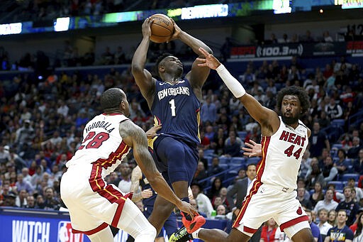 New Orleans Pelicans forward Zion Williamson (1) goes up for a basket as Miami Heat guard Andre Iguodala (28) and forward Solomon Hill (44) defend during the second half of an NBA basketball game in New Orleans, Friday, March 6, 2020. (AP Photo/Rusty Costanza)