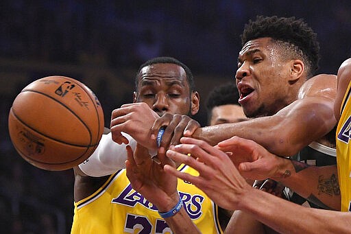 Los Angeles Lakers forward LeBron James, left, knocks the ball from the hands of Milwaukee Bucks forward Giannis Antetokounmpo during the first half of an NBA basketball game Friday, March 6, 2020, in Los Angeles. (AP Photo/Mark J. Terrill)