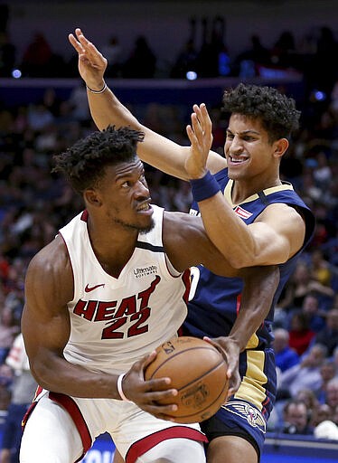 Miami Heat forward Jimmy Butler (22) drives to the basket as New Orleans Pelicans guard Frank Jackson defends during the first half of an NBA basketball game in New Orleans, Friday, March 6, 2020. (AP Photo/Rusty Costanza)