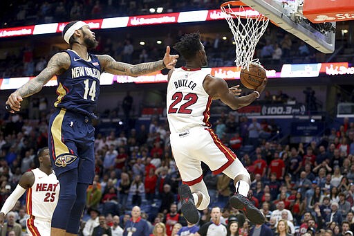 Miami Heat forward Jimmy Butler (22) goes for a layup as New Orleans Pelicans forward Brandon Ingram (14) defends during the first half of an NBA basketball game in New Orleans, Friday, March 6, 2020. (AP Photo/Rusty Costanza)