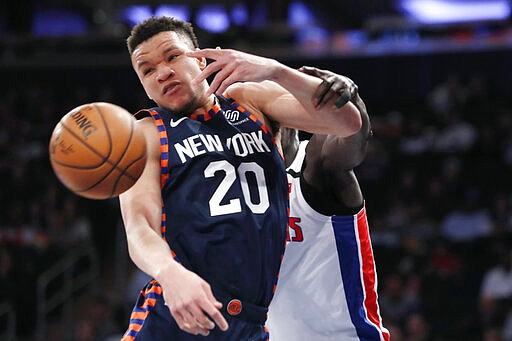 Detroit Pistons forward Tony Snell grabs New York Knicks forward Kevin Knox II (20)who was defending Smell beneath the Pistons' basket during the first half of an NBA basketball game in New York, Sunday, March 8, 2020. (AP Photo/Kathy Willens)