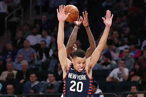 New York Knicks forward Kevin Knox II (20) blocks and fouls Detroit Pistons guard Jordan McRae, rear, during the first half of an NBA basketball game in New York, Sunday, March 8, 2020. (AP Photo/Kathy Willens)