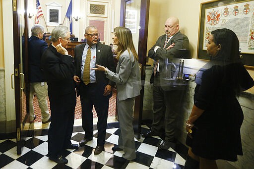 House Speaker Del. Eileen Filler-Corn, D-Fairfax, center, speaks to Sen. Tommy Norment, R-James City County, left, as Del. Luke Torian, D-Prince William, second from left, House minority leader Del Todd Gilbert, R-Shenandoah, and House majority leader, Del. Charniele Herring, D- Alexandria, look on in the entrance to the Senate at the Capitol Saturday March 7, 2020, in Richmond, Va. Both chambers agreed to extending the session to accommodate the budget and conference committee reports. (AP Photo/Steve Helber)