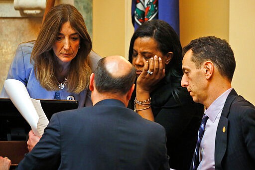 House Speaker, Del. Eileen Filler-Corn, left, majority leader, Del. Charniele Herring, D-Alexandria, center, and Del. Marcus Simon, D-Fairfax, right, confer with a clerk during the House session at the Capitol Saturday March 7 , 2020, in Richmond, Va. (AP Photo/Steve Helber)