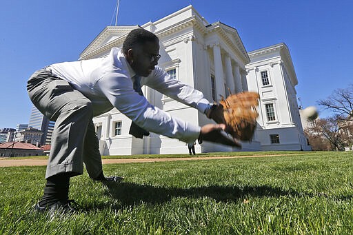 Del. Cliff Hayes, D-Chesapeake, reaches for a ball from a fellow Delegate during a break in the House session at the Capitol Sunday March 8, 2020, in Richmond, Va. Legislators have extended the 2020 legislative session by one day to complete work of most legislation. (AP Photo/Steve Helber)