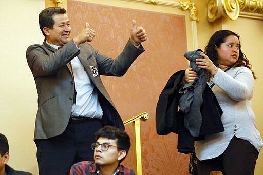 A visitor to the House gallery gives a thumbs up to fellow visitors after the house passedd legislation relating to state ID cards during the House session at the Capitol Saturday March 7 , 2020, in Richmond, Va. Lawmakers voted not to allow undocumented immigrants to get normal driver's licenses, but instead created a special new category IDs called a &quot;driver privilege card.&quot; (AP Photo/Steve Helber)