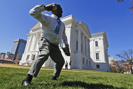 Del. Cliff Hayes, D-Chesapeake, tosses a ball to a fellow Delegate during a break in the House session at the Capitol Sunday March 8, 2020, in Richmond, Va. Legislators have extended the 2020 legislative session by one day to complete work of most legislation. (AP Photo/Steve Helber)