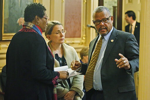 Del. Delores McQuinn, D-Richmond, left, speaks with State Sen. Siobhan Dunnavant, R-Henrico, center, and Del. Luke tori, D-Prince William, right during the House session at the Capitol Saturday March 7 , 2020, in Richmond, Va. Some of Virginia's scores of Confederate monuments could soon be removed under legislation state lawmakers approved Saturday. Del. Delores McQuinn, a Democrat from Richmond, was a sponsor of the legislation. (AP Photo/Steve Helber)