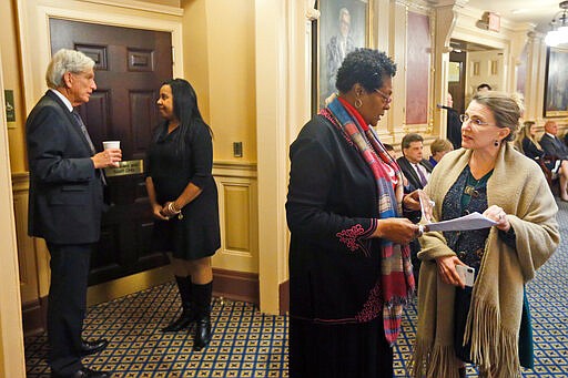 Del. Delores McQuinn, D-Richmond, second from right, speaks with State Sen. Siobhan Dunnavant, R-Henrico, right, as Senate majority leader, Sen. Richard Saslaw, D-Fairfax, left, talks with House majority leader Del. Charniele Herring, D-Alexandria, right, during the House session at the Capitol Saturday March 7 , 2020, in Richmond, Va. Some of Virginia's scores of Confederate monuments could soon be removed under legislation state lawmakers approved Saturday. Del. Delores McQuinn, a Democrat from Richmond, was a sponsor of the legislation. (AP Photo/Steve Helber)