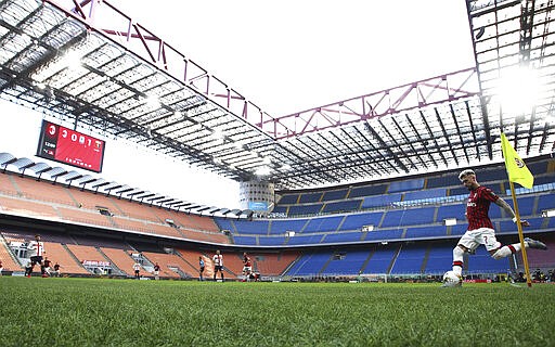 AC Milan's Samu Castillejo kicks from the corner in an empty stadium during the Serie A soccer match between AC Milan and Genoa at the San Siro stadium, in Milan, Italy, Sunday, March 8, 2020. Serie A played on Sunday despite calls from Italy&#146;s sports minister and players&#146; association president to suspend the games in Italy&#146;s top soccer division.  (Spada/LaPresse via AP)