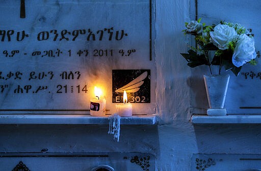 Candles are lit on a memorial wall during an anniversary memorial service to remember those who died when Ethiopian Airlines flight ET302, a Boeing 737 Max, crashed shortly after takeoff on March 10, 2019 killing all 157 on board, at the Holy Trinity Cathedral in Addis Ababa, Ethiopia Sunday, March 8, 2020. (AP Photo/Mulugeta Ayene)