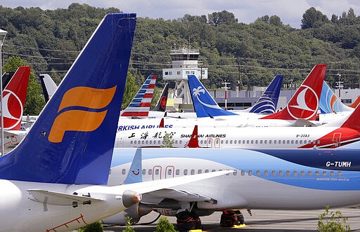 FILE - In this June 27, 2019 file photo, dozens of grounded Boeing 737 MAX airplanes crowd a parking area adjacent to Boeing Field in Seattle. When air safety investigators release an interim report on the crash of an Ethiopian Airlines Boeing 737 Max sometime before Tuesday, March 10, 2020, the one-year anniversary of the crash, they are likely to place the blame on the jet's automated flight control system as well as on the pilots and their training, but it's unclear yet which side will bear the brunt. (AP Photo/Elaine Thompson, File)