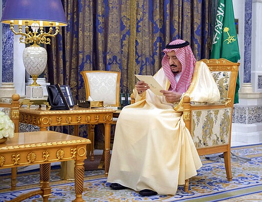 Saudi King Salman reads a document as he receives two newly appointed Saudi ambassadors at his palace in Riyadh, Saudi Arabia, Sunday, March 8, 2020. Two senior princes in Saudi Arabia are under arrest for not supporting Crown Prince Mohammed bin Salman, who has consolidated control of all major levers of power with the support of his father, King Salman, two people close to the royal family said Saturday. (Saudi Press Agency via AP)