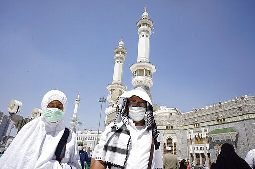 Muslim worshippers wear masks after the noon prayers outside the Grand Mosque, in the Muslim holy city of Mecca, Saudi Arabia, Saturday, March 7, 2020. Few worshippers were allowed to circumambulate the Kaaba, the cubic building at the Grand Mosque, over fears of the new coronavirus. (AP Photo/Amr Nabil)