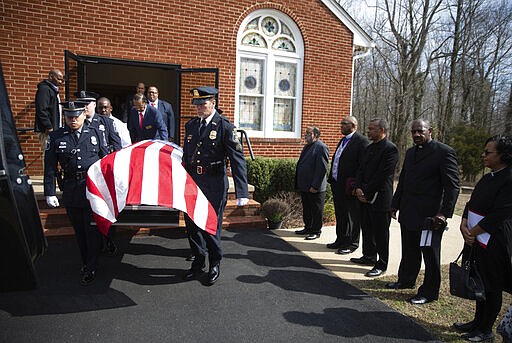 In a Monday, March 2, 2020 photo, Alexandria (Va.) police officers help with pall-bearer duties during the funeral service for Albert Beverly at People's Union Baptist Church in King George, Va. Beverly was the first African-American police officer in the Alexandria Police Department.(Mike Morones/The Free Lance-Star via AP)