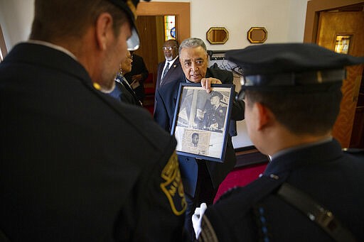 In a Monday, March 2, 2020 photo, William Beverly shows news clippings from when his brother Albert Beverly was named the first black police officer in Alexandria, Va. Friends, family and former colleagues attended the funeral service for Albert Beverly at People's Union Baptist Church in King George, Va. (Mike Morones/The Free Lance-Star via AP)