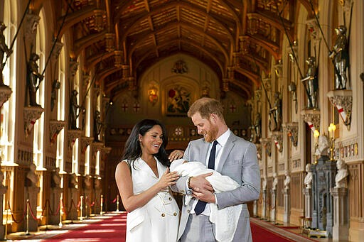 FILE - In this Wednesday May 8, 2019 file photo, Britain's Prince Harry and Meghan, Duchess of Sussex, during a photocall with their newborn son, in St George's Hall at Windsor Castle, Windsor, south England. Prince Harry and his wife, Meghan, are fulfilling their last royal commitment Monday March 9, 2020 when they appear at the annual Commonwealth Service at Westminster Abbey. It is the last time they will be seen at work with the entire Windsor clan before they fly off into self-imposed exile in North America. (Dominic Lipinski/Pool via AP, file)