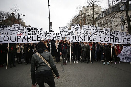 Women hold placards with the names of the women killed by their husband during a march as part of the International Women's Day, in Paris, Sunday, March 8, 2020. The banner on the right reads: &laquo;Guilty justice&#160;&raquo;. (AP Photo/Thibault Camus)