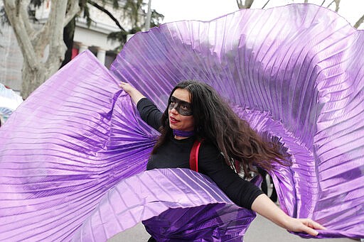 A protester dances during a march on International Women's Day in Madrid, Spain, Sunday, March 8, 2020, Thousands of women are marching in Madrid and other Spanish cities as part of International Women's Day. (AP Photo/Paul White)