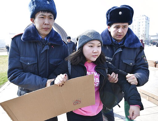 Kyrgyz policemen detain an activist of the Femen women's movement at Victory Square during celebration of the International Women's Day in Bishkek, Kyrgyzstan, Sunday, March 8, 2020. (AP Photo/Vladimir Voronin)