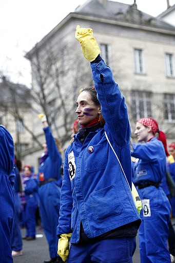 A woman raises her fist during a march as part of the International Women's Day, in Paris, Sunday, March 8, 2020. (AP Photo/Thibault Camus)