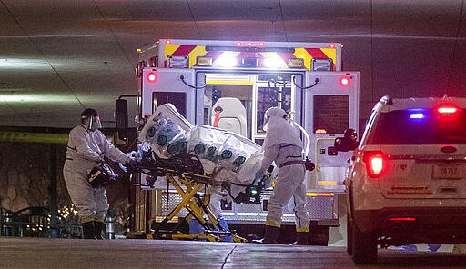 A woman who tested positive with the coronavirus is brought to the University of Nebraska Medical Center,  Friday March 6, 2020. She was transferred from Omaha's Methodist Hospital in an isolation pod inside an ambulance. (Chris Machian/Omaha World-Herald via AP)