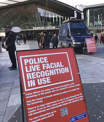 A mobile police facial recognition facility outside a shopping centre in London Tuesday Feb. 11, 2020, We don't accept this. This isn't what you do in a democracy," said Silkie Carlo, director of privacy campaign group Big Brother Watch, who are demonstrating against the surveillance.  London police started using facial recognition surveillance cameras mounted on a blue police van on Tuesday to automatically scan for wanted people, as authorities adopt the controversial technology that has raised concerns about increased surveillance and erosion of privacy. (AP Photo/Kelvin Chan)