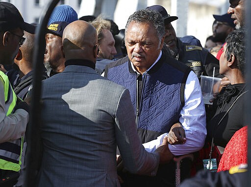 The Rev. Jesse Jackson is helped across the Edmund Pettus Bridge, Sunday, March 1, 2020, in Selma, Ala. (Curtis Compton/Atlanta Journal-Constitution via AP)