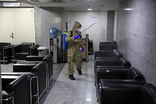 A man wearing protective gear disinfects Health Ministry headquarters because of the new coronavirus, in Tehran, Iran, Saturday, March 7, 2020. (AP Photo/Vahid Salemi)