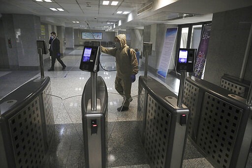 A man wearing protective gear disinfects Health Ministry headquarters because of the new coronavirus, in Tehran, Iran, Saturday, March 7, 2020. (AP Photo/Vahid Salemi)